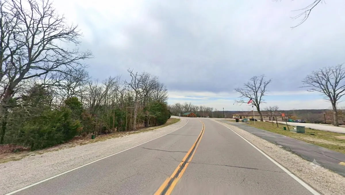 Wooded lot on the inside of a curve on Cherokee Road, homes visible across the way